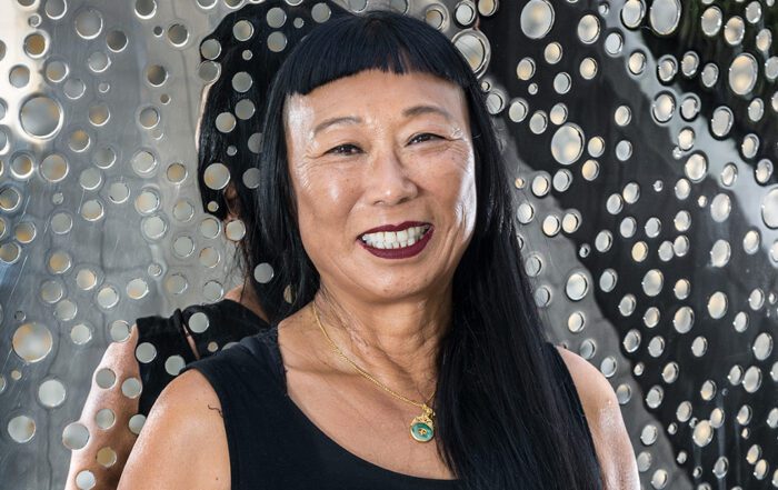 Lindy Lee in front of The Life of Stars, 2018, installation view, Art Gallery of South Australia, Adelaide, image courtesy the artist, Sullivan+Strumpf, Sydney and Singapore, and UAP, © the artist, photograph: Saul Steed